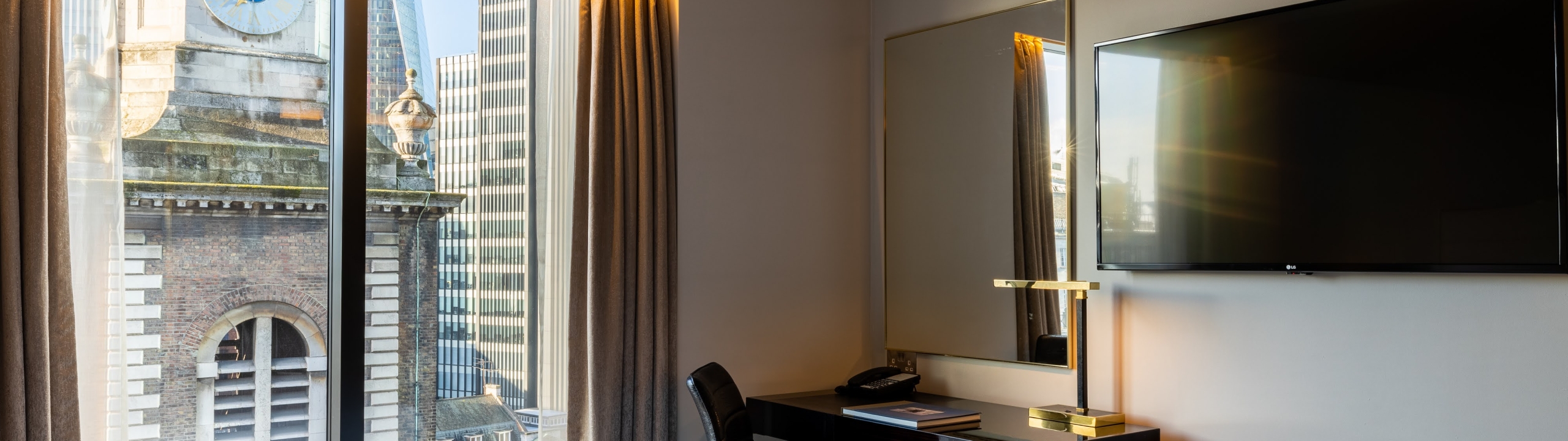 Well lit hotel room with a view of a church